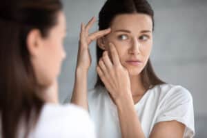 Anxious,Young,Woman,Look,In,The,Mirror,Worried,About,Wrinkle